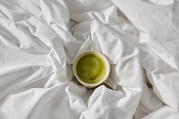 Image showing cup of matcha tea in bed at home