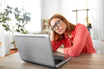 Image showing bored woman with laptop working at home office