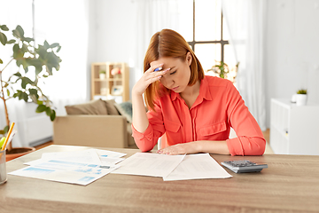 Image showing woman with calculator and papers working at home