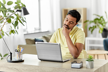 Image showing indian man with laptop thinking at home office