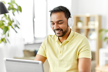 Image showing man in headphones with laptop working at home