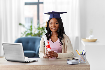 Image showing graduate student with laptop and diploma at home