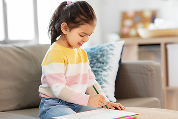 Image showing little girl drawing with coloring pencils at home