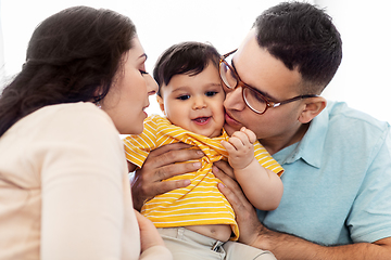 Image showing happy mother and father kissing baby son at home