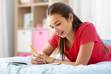 Image showing teenage girl writing to diary at home