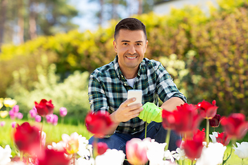 Image showing middle-aged man with smartphone at flower garden