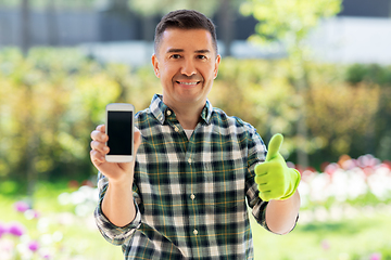 Image showing man with smartphone showing thumbs up at garden