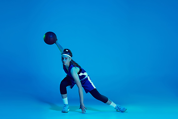 Image showing Young caucasian female basketball player isolated on blue studio background in neon light