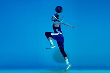 Image showing Young caucasian female basketball player isolated on blue studio background in neon light