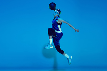 Image showing Young caucasian female basketball player isolated on blue studio background in neon light