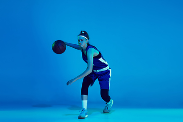 Image showing Young caucasian female basketball player isolated on blue studio background in neon light