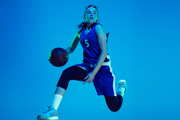 Image showing Young caucasian female basketball player isolated on blue studio background in neon light