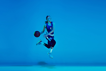 Image showing Young caucasian female basketball player isolated on blue studio background in neon light