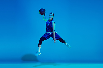 Image showing Young caucasian female basketball player isolated on blue studio background in neon light