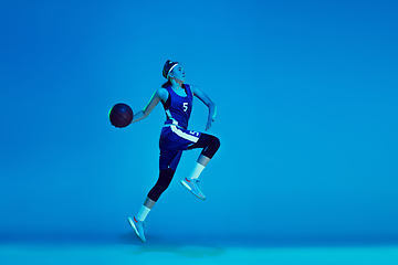 Image showing Young caucasian female basketball player isolated on blue studio background in neon light