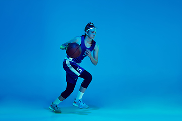 Image showing Young caucasian female basketball player isolated on blue studio background in neon light