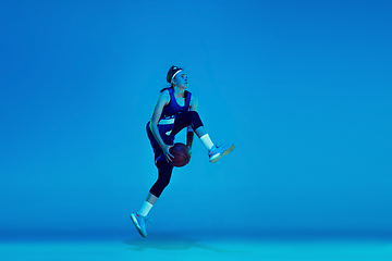 Image showing Young caucasian female basketball player isolated on blue studio background in neon light