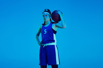 Image showing Young caucasian female basketball player isolated on blue studio background in neon light