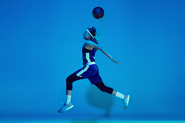 Image showing Young caucasian female basketball player isolated on blue studio background in neon light