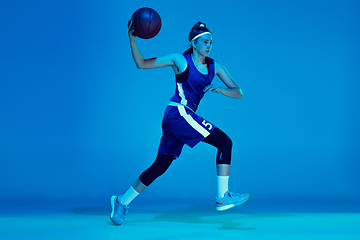 Image showing Young caucasian female basketball player isolated on blue studio background in neon light