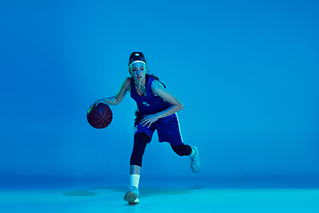 Image showing Young caucasian female basketball player isolated on blue studio background in neon light