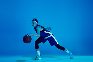 Image showing Young caucasian female basketball player isolated on blue studio background in neon light