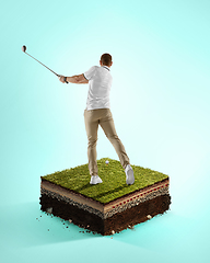 Image showing Golf player in a white shirt playing on blue background above stadium layers. Professional player practicing during gameplay, championship