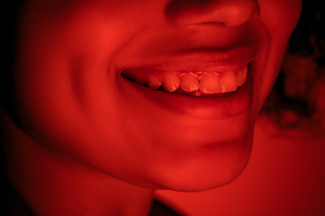 Image showing Beautiful african-american woman portrait isolated on red studio background in neon light, monochrome