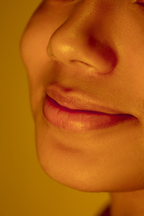 Image showing Beautiful african-american woman portrait isolated on yellow studio background in neon light, monochrome