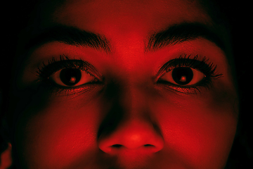 Image showing Beautiful african-american woman portrait isolated on red studio background in neon light, monochrome