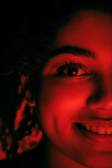 Image showing Beautiful african-american woman portrait isolated on red studio background in neon light, monochrome