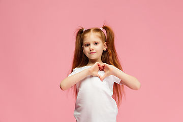 Image showing Happy caucasian little girl isolated on pink studio background. Looks happy, cheerful, sincere. Copyspace. Childhood, education, emotions concept