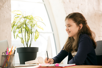 Image showing Little girl studying by group video call, use video conference with teacher, listening to online course