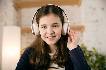 Image showing Little girl wearing headphones during online education course, lesson, view of screen