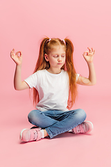 Image showing Happy caucasian little girl isolated on pink studio background. Looks happy, cheerful, sincere. Copyspace. Childhood, education, emotions concept