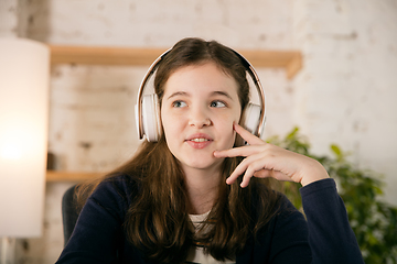 Image showing Little girl wearing headphones during online education course, lesson, view of screen