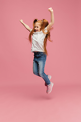Image showing Happy caucasian little girl isolated on pink studio background. Looks happy, cheerful, sincere. Copyspace. Childhood, education, emotions concept