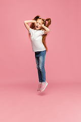 Image showing Happy caucasian little girl isolated on pink studio background. Looks happy, cheerful, sincere. Copyspace. Childhood, education, emotions concept