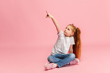 Image showing Happy caucasian little girl isolated on pink studio background. Looks happy, cheerful, sincere. Copyspace. Childhood, education, emotions concept