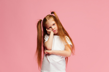 Image showing Happy caucasian little girl isolated on pink studio background. Looks happy, cheerful, sincere. Copyspace. Childhood, education, emotions concept