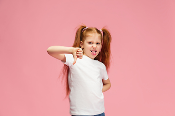 Image showing Happy caucasian little girl isolated on pink studio background. Looks happy, cheerful, sincere. Copyspace. Childhood, education, emotions concept