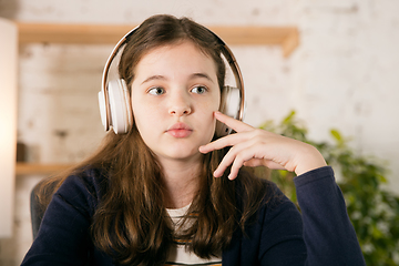 Image showing Little girl wearing headphones during online education course, lesson, view of screen