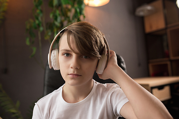 Image showing Little boy wearing headphones during online education course, lesson, view of screen