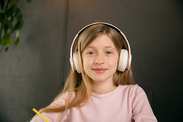 Image showing Little girl wearing headphones during online education course, lesson, view of screen