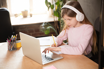 Image showing Little girl studying by group video call, use video conference with teacher, listening to online course