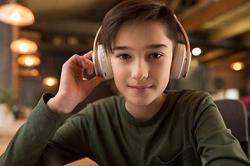 Image showing Little boy wearing headphones during online education course, lesson, view of screen