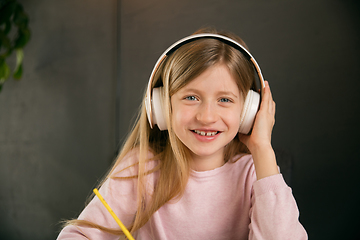 Image showing Little girl wearing headphones during online education course, lesson, view of screen