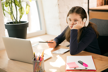 Image showing Little girl studying by group video call, use video conference with teacher, listening to online course