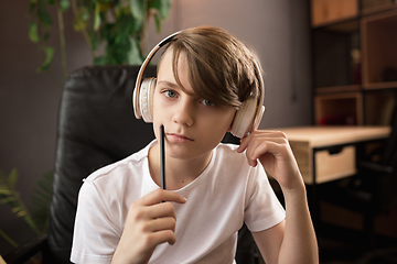 Image showing Little boy wearing headphones during online education course, lesson, view of screen