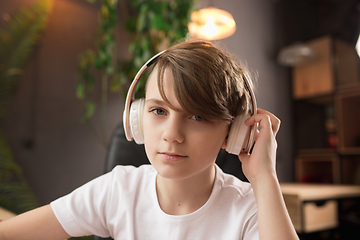 Image showing Little boy wearing headphones during online education course, lesson, view of screen